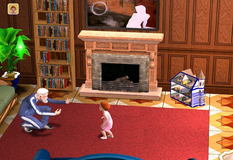 Screenshot of The Sims 2 showing a cozy living room with wood-paneled walls. An older Sim in a blue track suit is kneeling on a large red rug, holding their arms out to encourage a toddler Sim in a pink dress who is taking steps toward them. A fireplace, a tall bookshelf, and a dollhouse are visible in the background, with a green Plumbob floating above the older Sim.