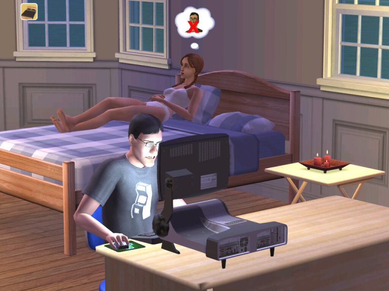 Screenshot of The Sims 2 showing a bedroom at night. In the foreground, a Sim wearing glasses and a grey t-shirt with an arcade graphic is sitting at a desk playing on a bulky desktop computer. In the background, another Sim in white sleepwear is lying awake in bed, with a thought bubble displaying a red 'X' over a Sim's face.