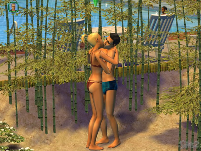 Screenshot of The Sims 2 showing two Sims embracing and kissing outdoors during the daytime. The Sims are wearing swimwear and are standing on sand next to tall green bamboo plants. In the background, a bright blue swimming pool is visible, along with blue lounge chairs where another Sim is relaxing. The game's user interface shows a Sim portrait in the top left, and the classic The Sims 2 logo is in the bottom right corner.